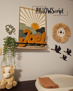 Load image into Gallery viewer, Decorative wall art using personalized PillowScript pillow with 'Joel' on it and a lion head, surrounded by plants and toys.
